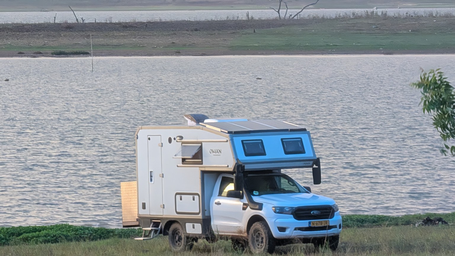 An overland camper with a wide view across the water