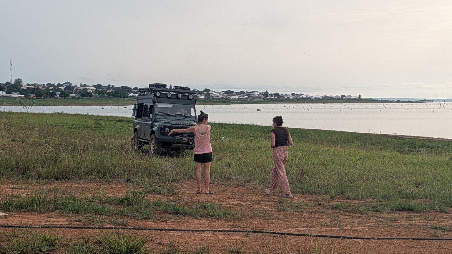 Overlanders arriving in a Land Rover beside the water